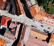 Zhruba uprostřed leteckého snímku je na vozovce vidět šedý čtverec. Zde Pražská brána stávala.
